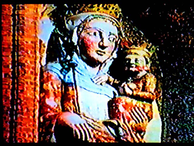 Fot. #C2b (środek): Klatka starego filmu ukazująca figurę krzyzackiej Madonny z zamku w Malborku, wraz z wnęką w murze w jakiej ona stała.